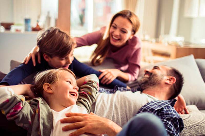 Happy family in Pennsylvania, playing together on home's couch.